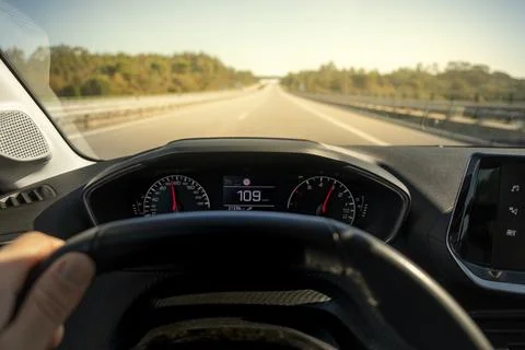 Driver view to the speedometer at 109 kmh, on a road blurred in motion. Stock Photos