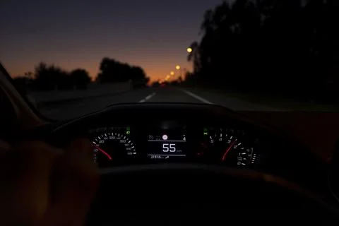 Driver view to the speedometer at 55 kmh or 55 mph, on a road blurred in motion. Stock Photos