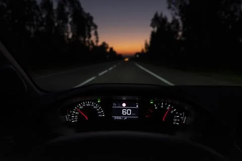 Driver view to the speedometer at 60 kmh or 60 mph, on a road blurred in motion. Stock Photos