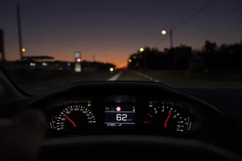 Driver view to the speedometer at 62 kmh or 62 mph, on a road blurred in motion. Stock Photos