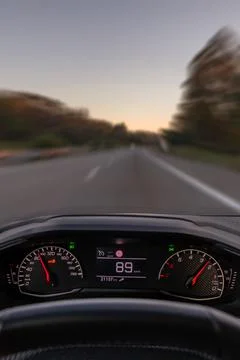 Driver view to the speedometer at 89 km h, driver POV of the road landscape. Stock Photos
