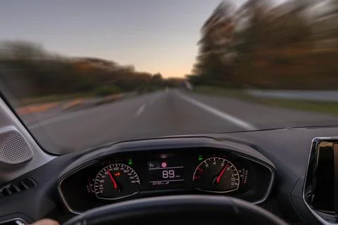 Driver view to the speedometer at 89 km h, driver POV of the road landscape. Stock Photos