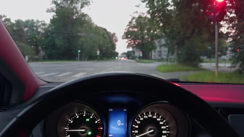 Driver viewpoint waiting at city intersection with glowing traffic lights, car Stock Footage 344993182