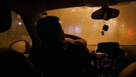 The driver waits in the car when the rain ends. Alone sad driver Stock Footage 82739920