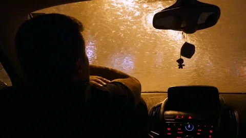 The driver waits in the car when the rain ends. Alone sad driver Stock Footage 82741720