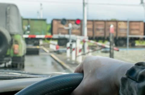 The driver waits for the freight train to pass Stock Photos