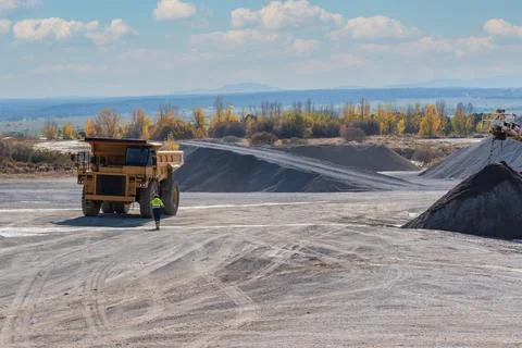 Driver walking towards a large dump truck for quarry work. Stock Photos
