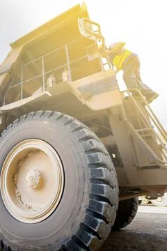 Driver walks up a large mining dump truck. Stock Photos