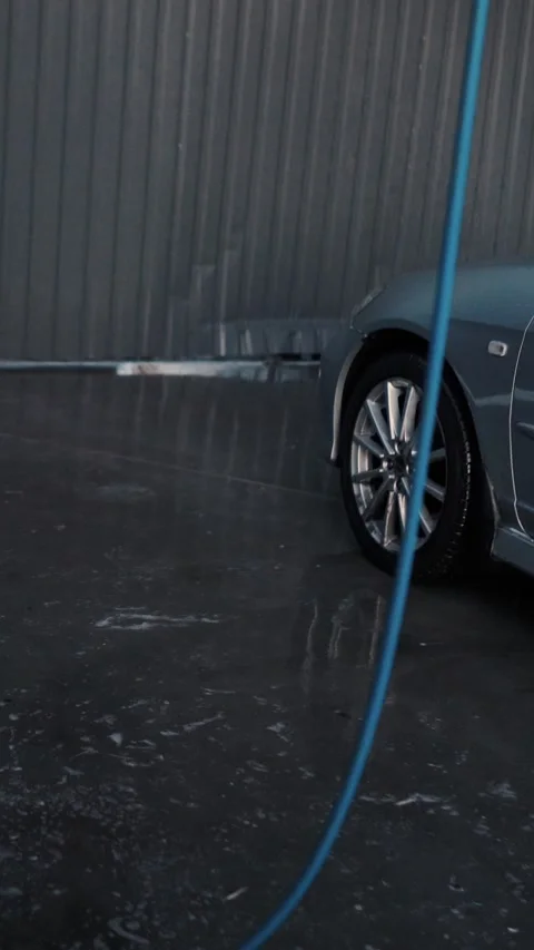 A driver washes a car with water, foam, and wax at a self-service car wash Stock-Footage 333595188