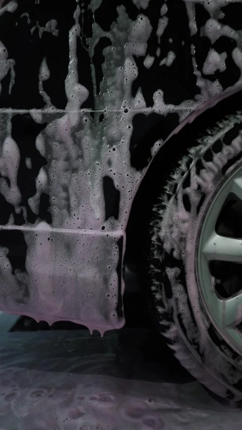 A driver washes a car with water, foam, and wax at a self-service car wash 库存影片 333595216