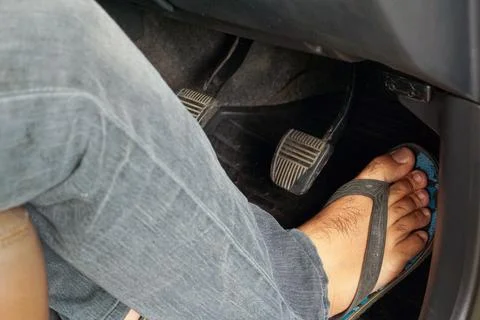 Driver wearing flip-flops operates car accelerator. Unsafe footwear and roa.. Stock Photos