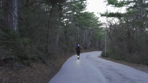 A driver wearing a protective helmet and a powerful electric scooter drives Stock Footage 153056381