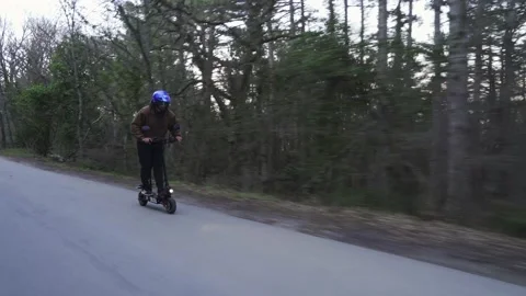 A driver wearing a protective helmet and a powerful electric scooter drives Video stock 153056663