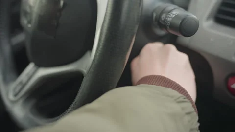 Driver in winter jacket inserts key into car ignition 스톡 동영상 310180129