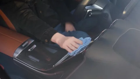 A driver wipes the digital screen in a car with a special cloth. Stock Footage 321311784