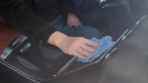 A driver wipes the digital screen in a car with a special cloth. Stock Footage 321311787