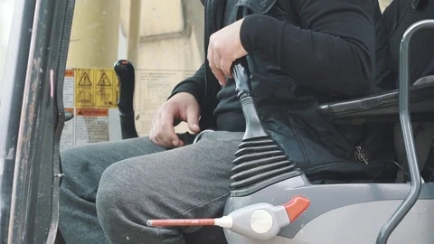 Driver in yellow excavator cabin pulling switches roating it around, slowmotion Stock Footage 72631821