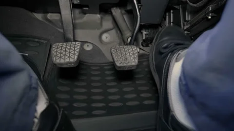The driver's feet are very active works with the gas, brake and clutch pedals Stock Footage 138288699