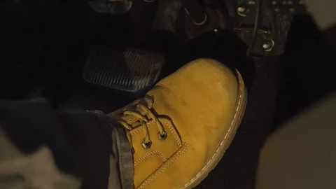 Driver's foot switching from brake to gas pedal at night extended Stock Footage