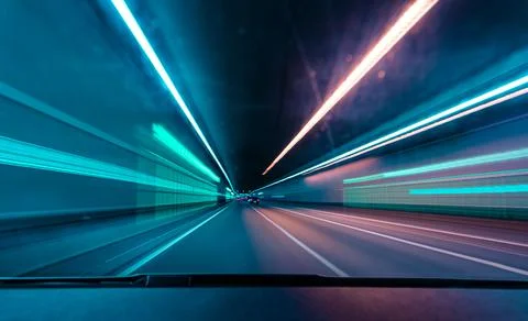 Drivers front view, driving fast in a tunnel by var with lots of blurry lights. Stock Photos