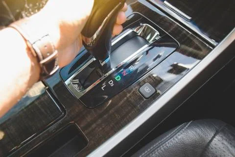 The driver's hand moved the gear selector to the drive (D) mode Stock Photos