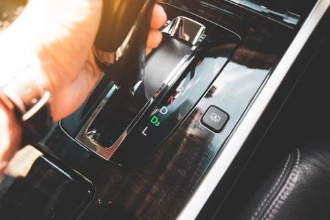 The driver's hand moved the gear selector to the drive three (D3) mode Stock Photos