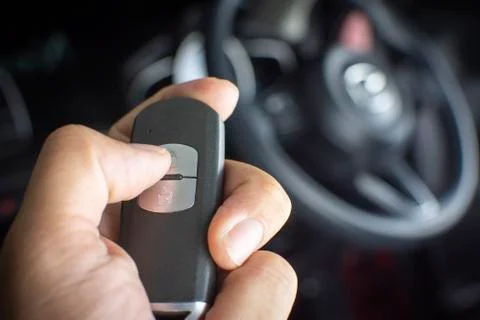 The driver's hand is pressed to the remote car keyless Foto stock