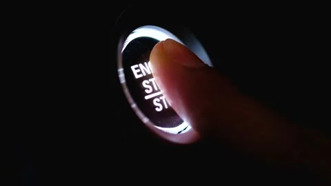 The driver's hand is pressing the car start button. Concept of transportation an Stock Footage 145298054