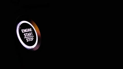 The driver's hand is pressing the car start button. Concept of transportation an Stock Footage 231971050