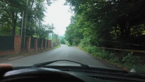 Driver's hand steering car on a winding countryside road Video stock 346319064