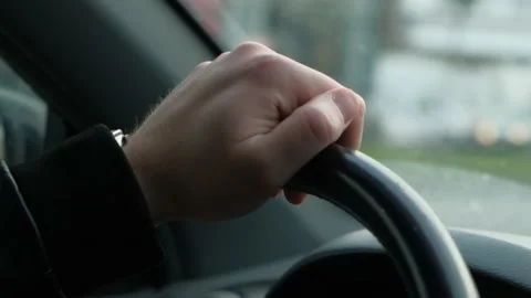 The driver's hand on the steering wheel of the car while driving, closeup Stock Footage 235373115
