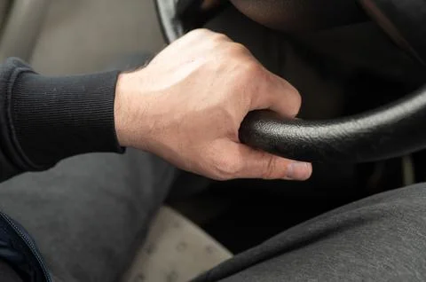 Drivers hand on the steering wheel, close-up view showing control, focus, and Stock Photos