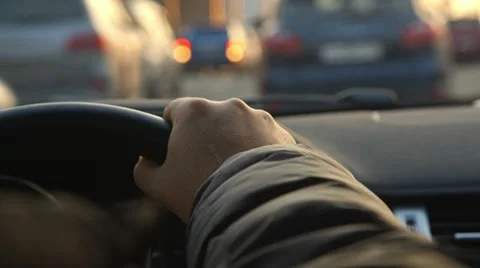 Driver's hand on the steering wheel, driving in the streets of a city Video stock 49404774
