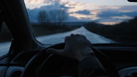 Driver's hand on steering wheel during ride at countryside road in the evening. Stock Footage 152011026
