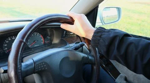 The driver's hand on the steering wheel of a moving car. Stockfoto's