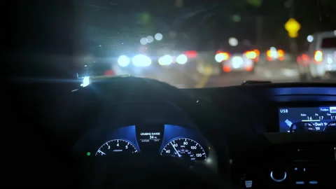 The driver's hand on the steering wheel of the night road and the glare of Stock Footage 166710569