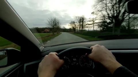 Driver's hand on the steering wheel while driving a car on the countryside road. Stock-Footage 336266401