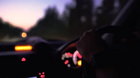 Driver's hands on car steering wheel during night journey, close-up Stock Footage 133375276