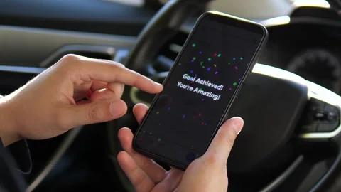 : A drivers hands hold a phone displaying a fitness app that suddenly shows a Stock-Footage 316387172