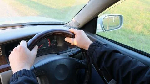 The driver's hands on the steering wheel of a right-hand drive car Stock Photos