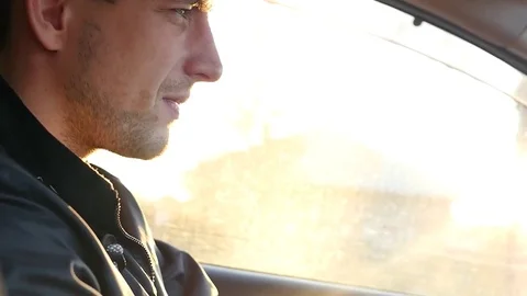 The driver's journey in the car at sunset in the bright rays of the shimmering Stock Footage