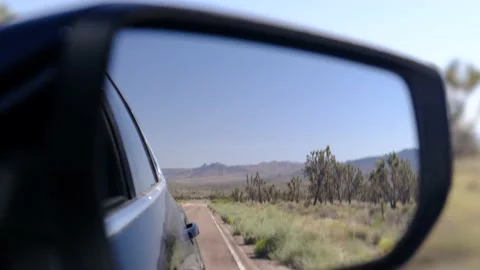 Driver's point of view in vehicle rearview mirror view view empty road Stock Footage 232163039