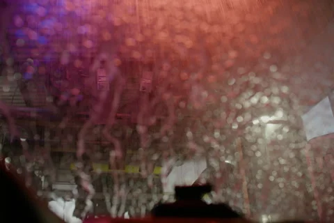 Driver's POV Going Through a Colorful Carwash. Soap, Water and Suds Wash Windows Stock Footage 298277010