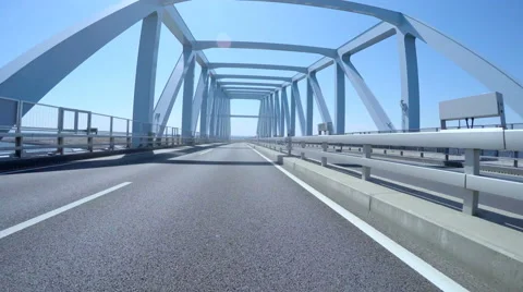 Driver's POV through Tokyo Gate Bridge in blue skies. Stock Footage