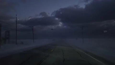 Driver's view of a car running on a road surrounded by snow storm. Night Stock Footage 234379056