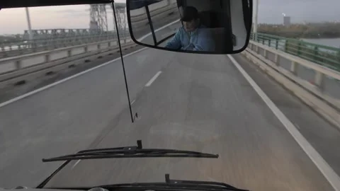Driver's view of a highway from inside a vehicle, with the rearview mirror Stock Footage 253704577