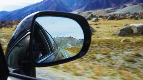 From driver's view, mirror captures distant peaks and open plains Stock Footage 342734425