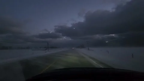 Driver's view by night of a car running on a road surrounded by snow storm Stock Footage 236533208