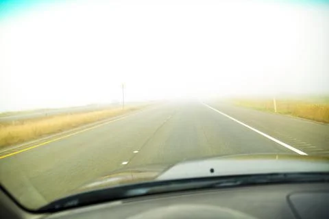 A driver's view of the road ahead with thick fog across the road, limited v.. Stock Photos