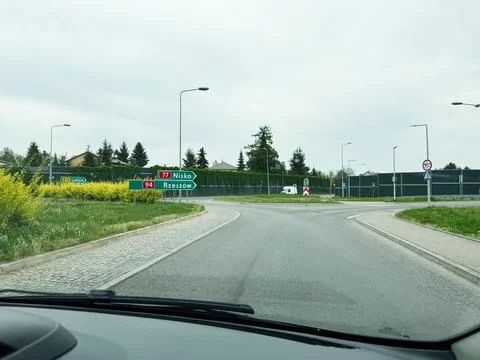 Driver's view of a roundabout with directional road signs to Nisko and Rzes.. Stock Photos